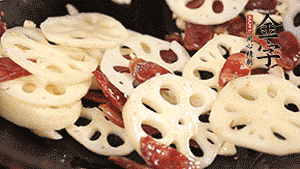 依次下香腸片、藕片翻炒均勻，加適量清水燜熟。