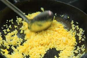 大火加熱炒鍋，再入油，燒到四至五成熱時倒入雞蛋液，在未凝結(jié)之前，加米飯煸炒，不停翻炒并用鍋鏟將成塊的米飯碾開、撥散。