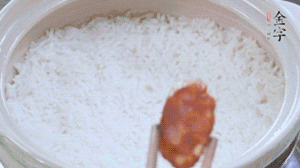 煮開后轉小火，當米飯出現小孔時，鋪上金字麻辣香腸。