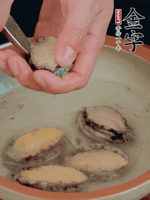 鮑魚加鹽、清水浸泡，用勺子挖出鮑魚肉。