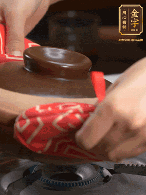 中火調成小火，鋪上香腸蓋蓋燜5分鐘。不斷轉動瓦煲，讓側壁的飯形成飯焦