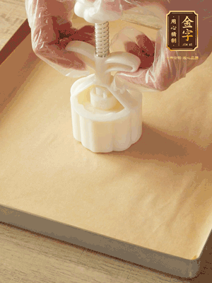 取一個(gè)面團(tuán)，捏扁，中間厚，四周薄。虎口往上推，直到收口，把餅胚放入模具里，壓2-3下